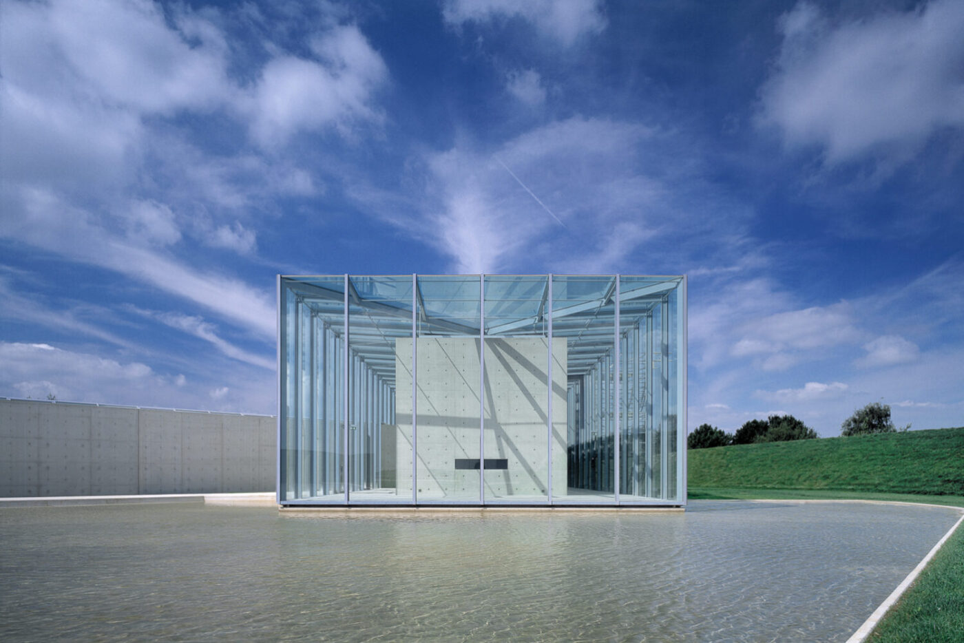 Gebäude der Langen Foundation. Ansicht von vorne mit Wasser im Vordergrund.